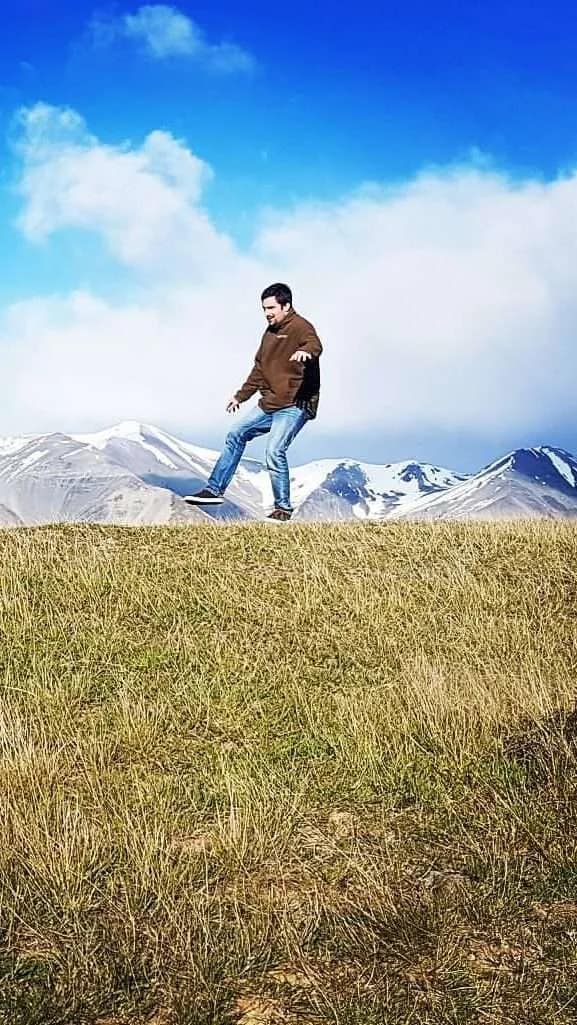 Laugharne Kemp practicing his work life balance on the edge of a grassy knoll. Cave Stream, New Zealand.